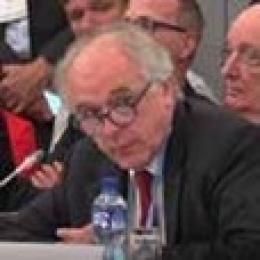 A man sitting at a table with a microphone.
