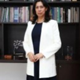 A woman standing in front of a bookcase.