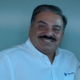 A man and woman posing for a photo in a white shirt.