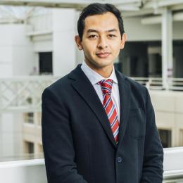 A man in a suit and tie standing on a balcony.