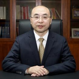 A man in a suit and tie sitting at a desk.