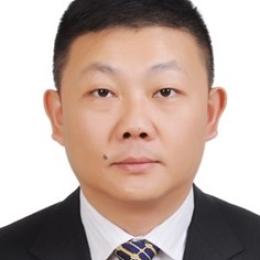 An asian man in a suit and tie.