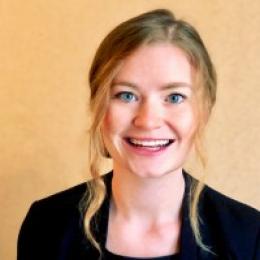 A smiling woman in a black blazer.