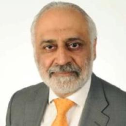 A man in a suit and orange tie.
