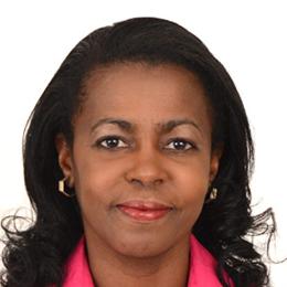 A woman in a pink shirt is posing for a photo.