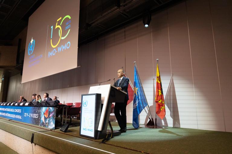 a man standing at a podium in front of a crowd.