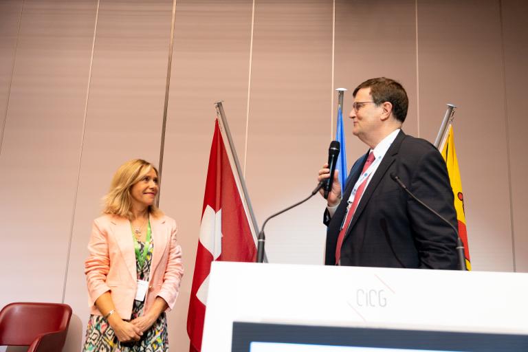 Ceremony with smiling man and woman with flags