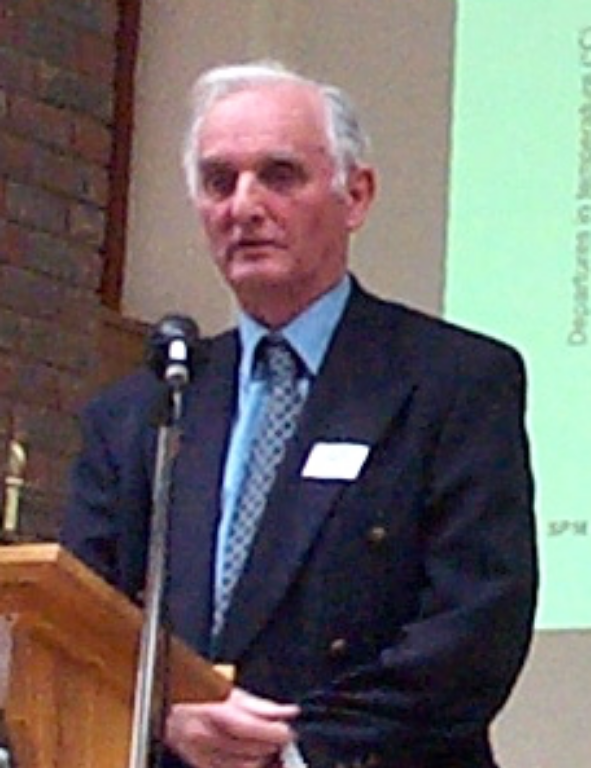 A man in a suit standing at a podium.