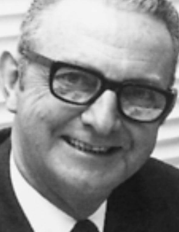 A black and white photo of a man wearing glasses.