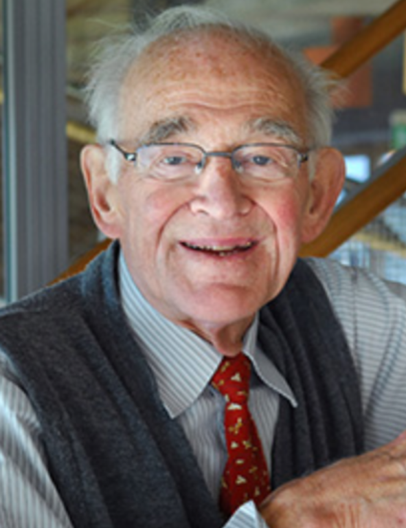 An older man wearing glasses and a vest.