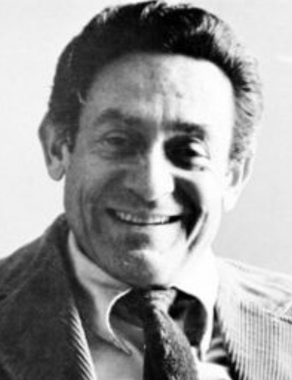 A black and white photo of a man smiling.