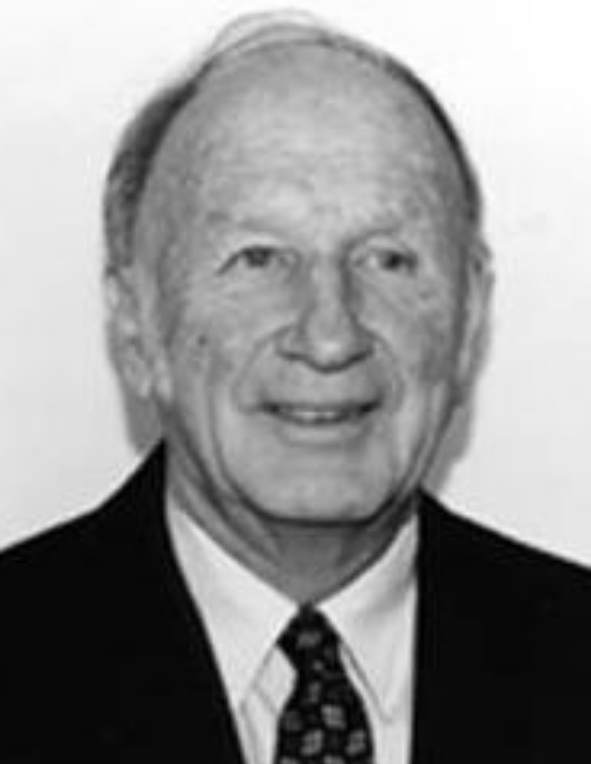 A black and white photo of an older man in a suit.