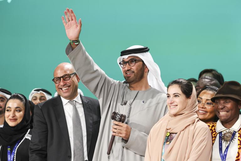 A group of people waving in front of a crowd.