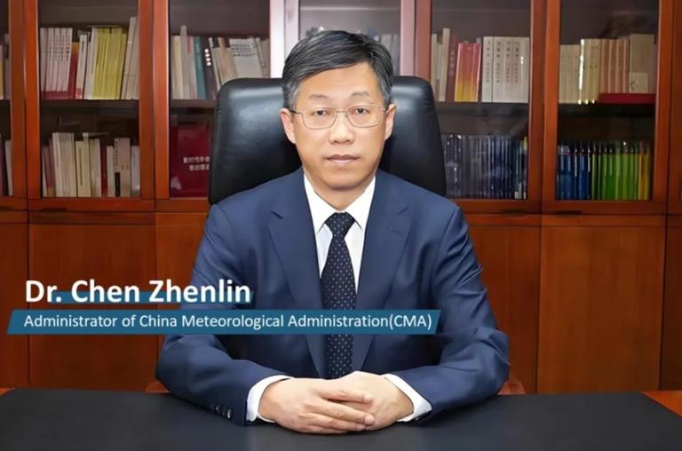 A man in a dark suit and tie sits at a desk in front of bookshelves. Text on the image reads: "Dr. Chen Zhenlin, Administrator of China Meteorological Administration (CMA).