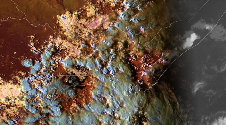 Satellite image shows cloud cover over a brown and green landmass with state boundary lines visible; sunlight and shadow divide the image.