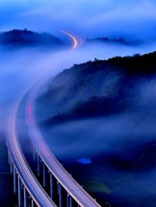 An aerial view of a highway in the fog.