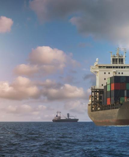 A massive cargo ship navigating the open sea, surrounded by water
