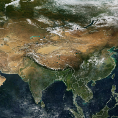 Satellite view of Asia showing diverse landscapes including deserts, mountains, forests, and bodies of water, with snow covering the northern regions.