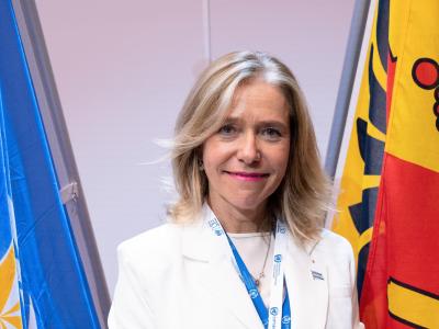 Celeste Saulo in front of the WMO and Geneva Canton flags