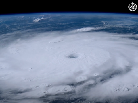 Satellite view of a large cyclone over the ocean, displaying a distinct eye and swirling cloud patterns.